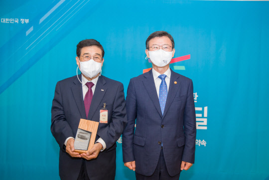 30일 광화문 정부서울청사에서 개최된 '이달의 한국판뉴딜' 감사패 수여식에서 문성혁(오른쪽) 해양수산부장관과 배재훈 HMM 대표이사가 기념촬영을 하고 있다. <HMM 제공>